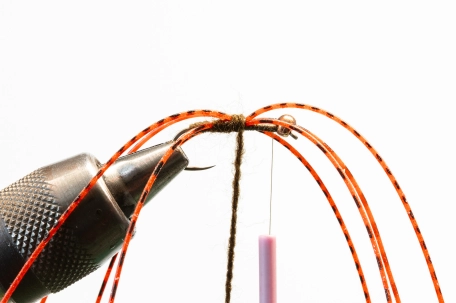 Tying in the legs with the yarn held in hackle pliers Tying in the legs with the yarn held in hackle pliers